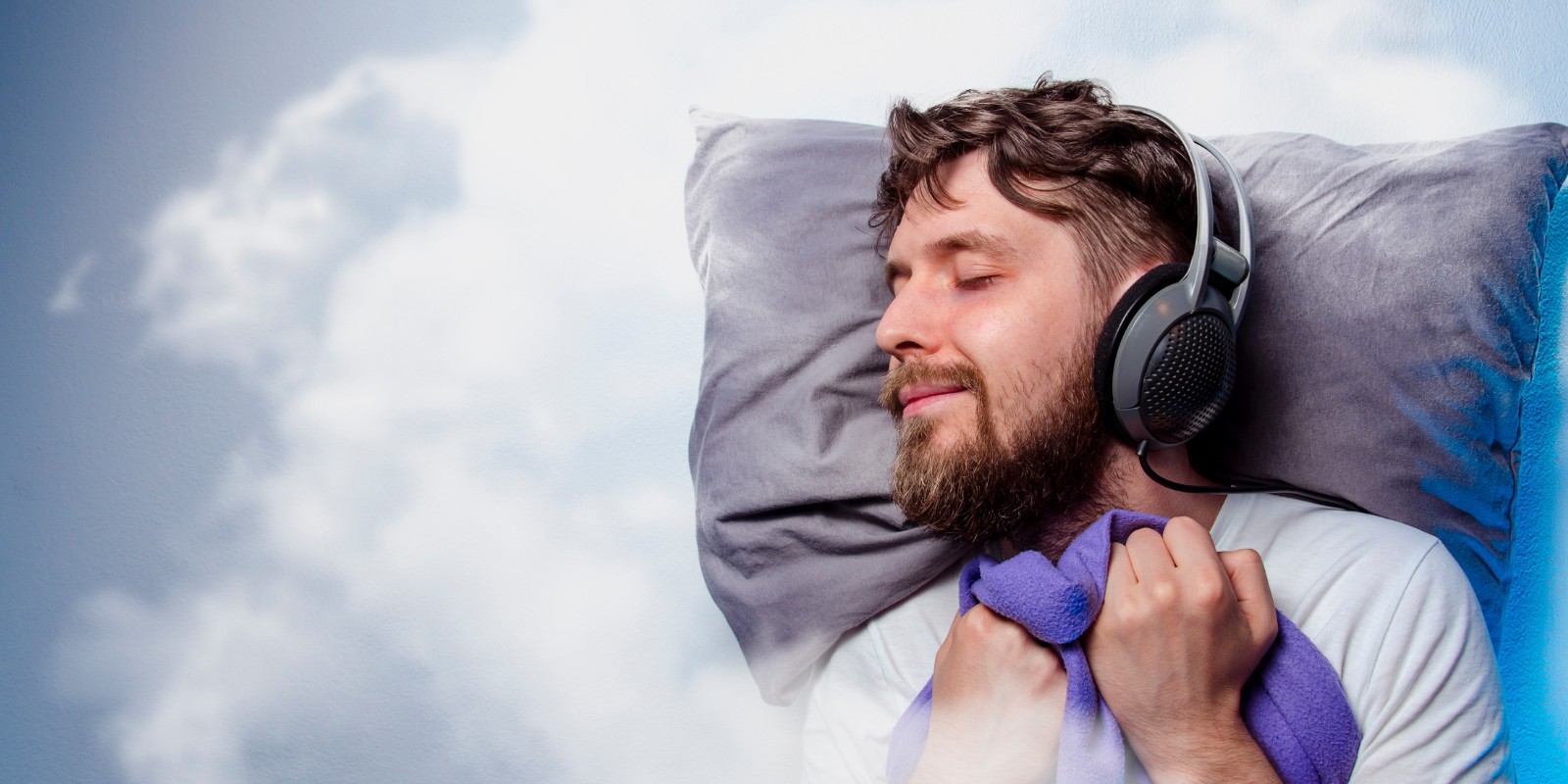 Yrityspodcast voi olla sleeper hit – kuvassa hymyilevä mies nukkuu kuulokkeet päässään – Suomen Podcastmedia